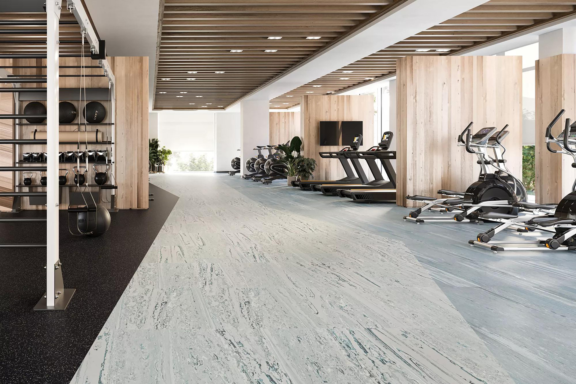 A modern gym with treadmills, exercise bikes, and weight racks on a light wood and gray floor. Wood paneling and large windows provide a bright and open atmosphere.